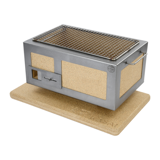 A silver-colored Kasai Konro Grill placed on a beige heat mat.